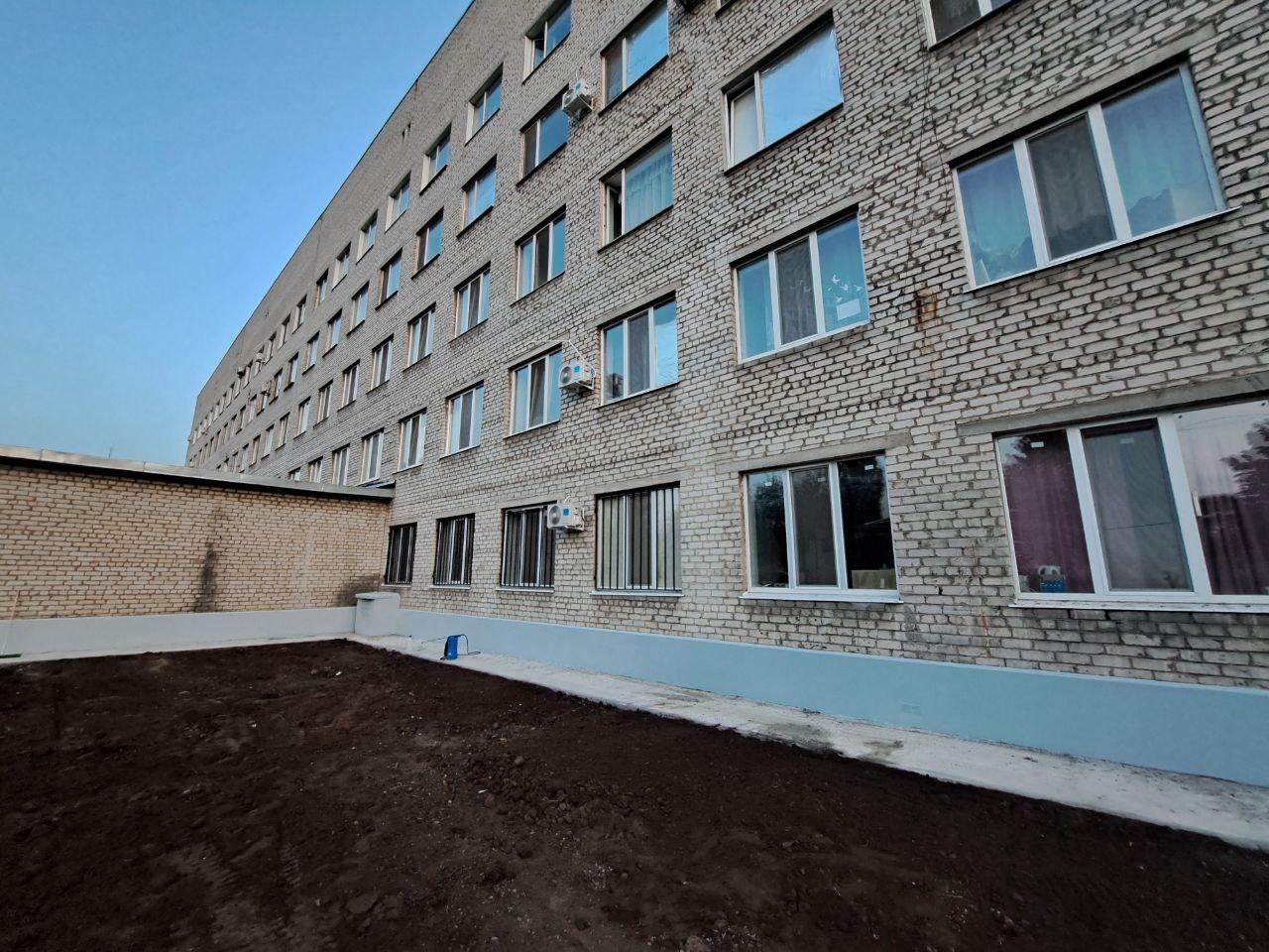Рабочая бригада от Забайкалья окрасила восстановленный цоколь ЦРБ Старобешево